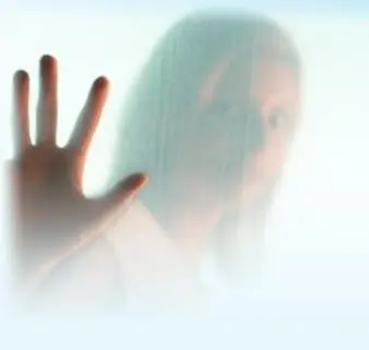 A hand pressed against frosted glass, seen in soft silhouette